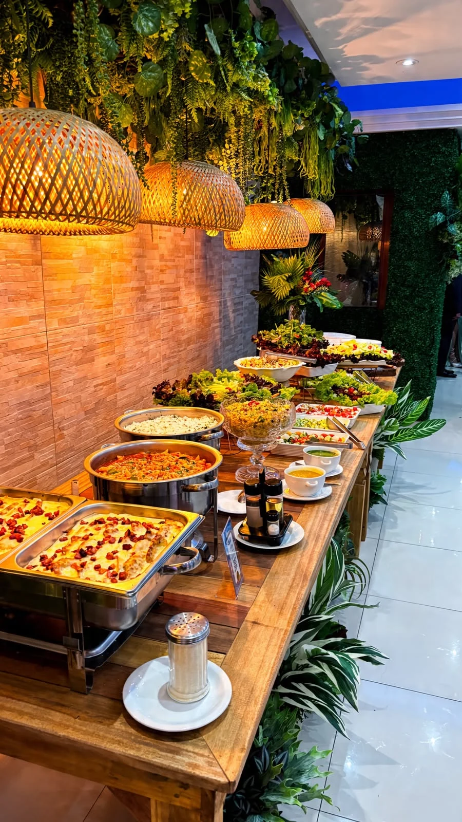 Buffet da Star Fashion com pratos quentes, saladas e acompanhamentos sob luminárias decorativas