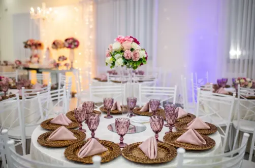 Salão de festas decorado com mesas e arranjos florais na Star Fashion